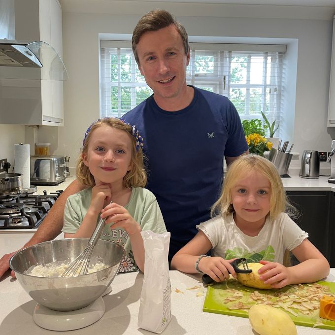 Father with two young daughters cooking