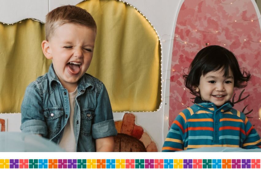 Two toddlers laughing and playing