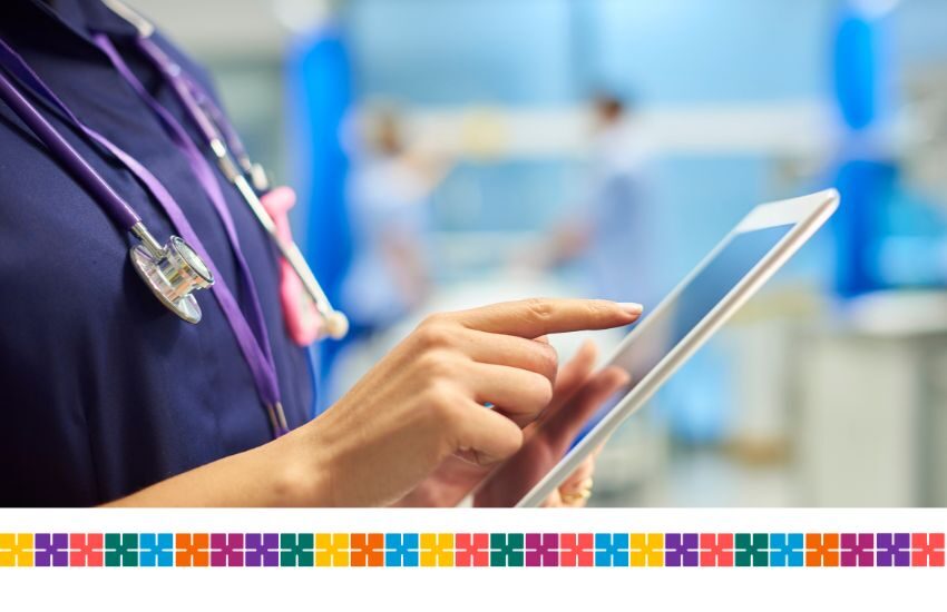 Clinician in hospital uses tablet.